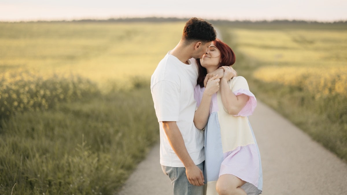 A man and a woman kissing on a road